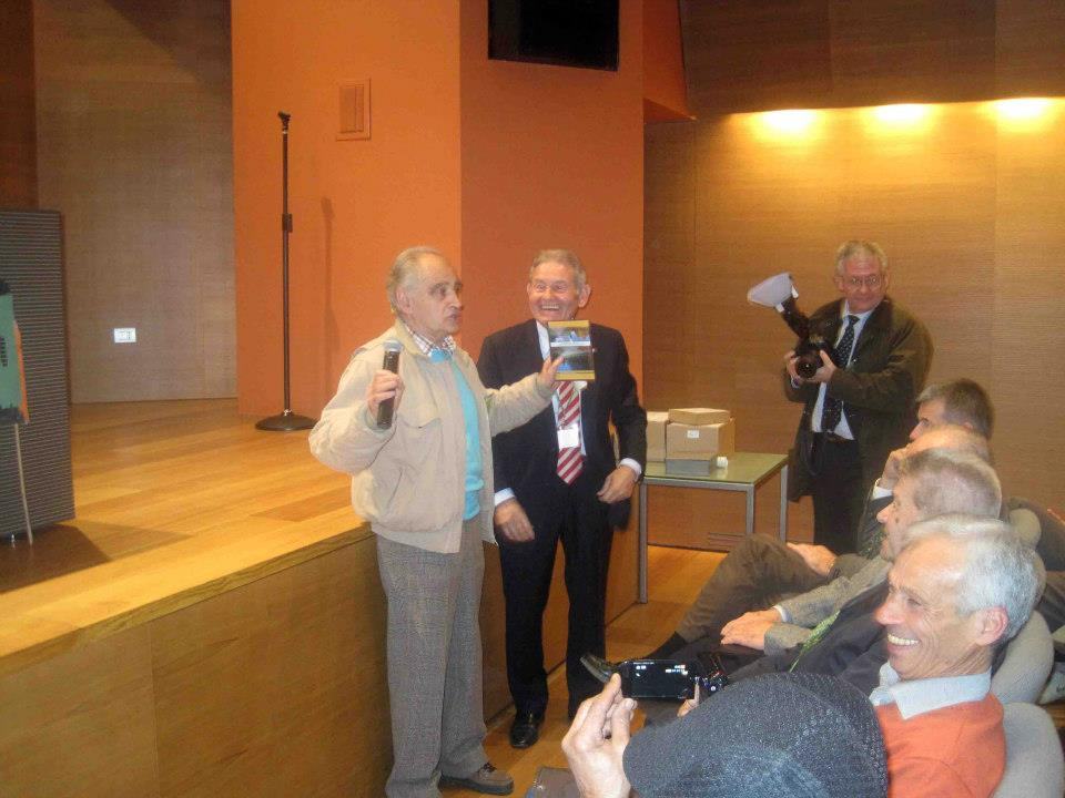 Un ospite con il microfono e un altro che mostra un libro